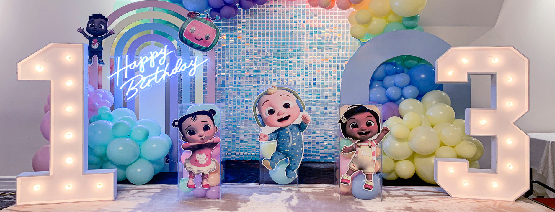 Colorful pre-designed balloon decoration setup with happy birthday sign, cartoon characters, and custom-designed packages for children's birthday party in Toronto